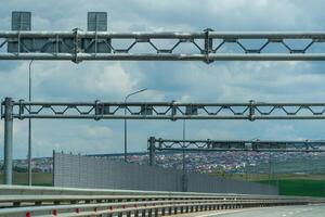A highway with a lot of traffic lights and a lot of tall metal structures. The sky is cloudy and the city is in the background. photo