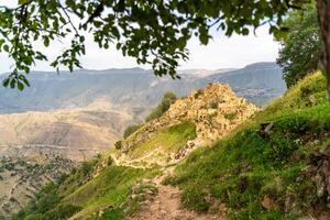 Dagestan Gamsutl. Ancient ghost town of Gamsutl old stone houses in abandoned Gamsutl mountain village in Dagestan, Abandoned etnic aul, summer landscape. photo