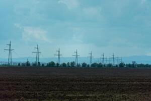 High voltage towers with sky background. Power line support with wires for electricity transmission. High voltage grid tower with wire cable at distribution station. Energy industry, energy saving photo