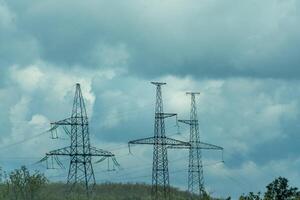 High voltage towers with sky background. Power line support with wires for electricity transmission. High voltage grid tower with wire cable at distribution station. Energy industry, energy saving photo