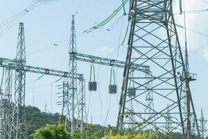High voltage towers with sky background. Power line support with wires for electricity transmission. High voltage grid tower with wire cable at distribution station. Energy industry, energy saving photo