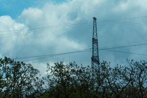 High voltage towers with sky background. Power line support with wires for electricity transmission. High voltage grid tower with wire cable at distribution station. Energy industry, energy saving photo