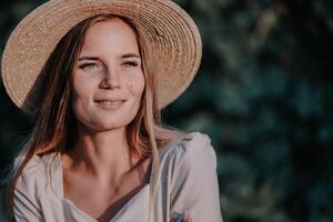 Woman with straw hat stands in front of vineyard. She is wearing a light dress and posing for a photo. Travel concept to different countries photo