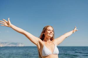 A woman in a bikini is smiling and waving at the camera photo