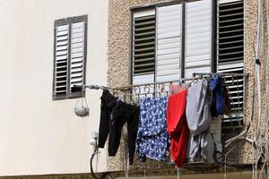 Washed laundry hangs on a rope outside the window. photo