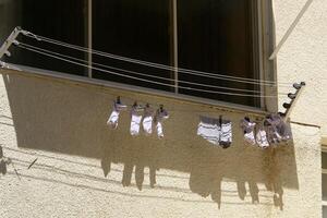 Washed laundry hangs on a rope outside the window. photo