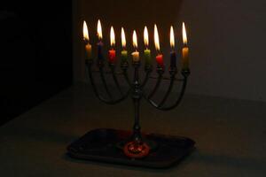 A burning wax candle stands on the table. photo