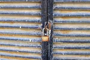 An old metal lock hangs on the fence. photo