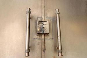 An old metal lock hangs on the fence. photo