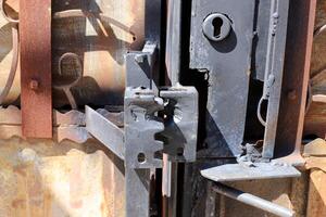 An old metal lock hangs on the fence. photo
