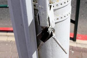 An old metal lock hangs on the fence. photo