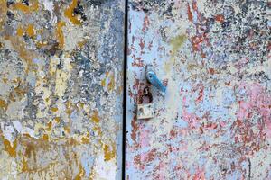 An old metal lock hangs on the fence. photo