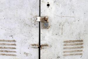 An old metal lock hangs on the fence. photo