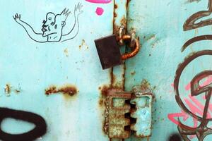 An old metal lock hangs on the fence. photo