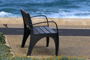 A bench for relaxing in a city park on the seashore. photo