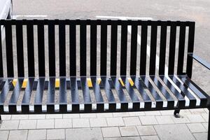 A bench for relaxing in a city park on the seashore. photo