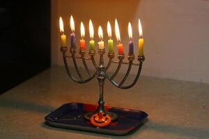 A burning wax candle stands on the table. photo