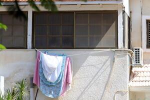 Washed laundry hangs on a rope outside the window. photo