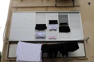 Washed laundry hangs on a rope outside the window. photo