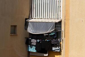 Washed laundry hangs on a rope outside the window. photo