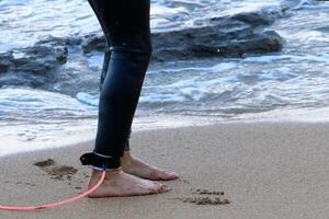 An athlete walks barefoot on the sand on the seashore. photo