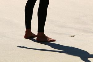 An athlete walks barefoot on the sand on the seashore. photo
