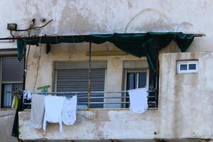 Washed laundry hangs on a rope outside the window. photo
