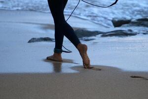 An athlete walks barefoot on the sand on the seashore. photo