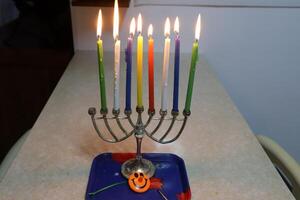 A burning wax candle stands on the table. photo