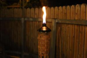 A burning wax candle stands on the table. photo