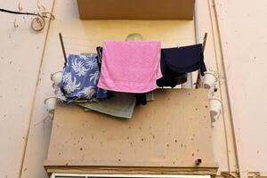 Washed laundry hangs on a rope outside the window. photo