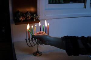 A burning wax candle stands on the table. photo