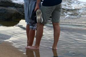 An athlete walks barefoot on the sand on the seashore. photo