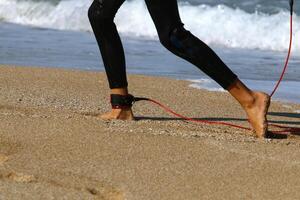 An athlete walks barefoot on the sand on the seashore. photo