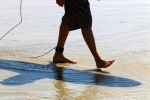 An athlete walks barefoot on the sand on the seashore. photo