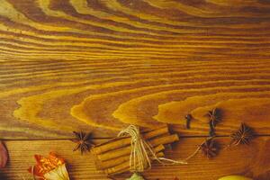 Wooden table. Autumn background with dry leaves, acorns cinnamon spices on wooden table. Copy space. Autumn background with dry leaves, cinnamon spices on photo