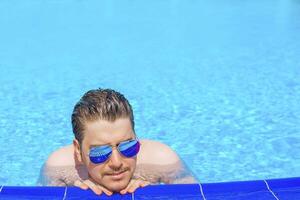 Man swimming in the pool. Man in pool having fun on summer holidays. Young man swimming and lurking on vacation. photo
