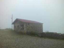 Old stone house in Dumanli Village in foggy weather, Gumushane, Turkiye. Santa Ruins. photo