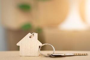 House keys on keyring in the shape of a wooden house with copy-space for text photo