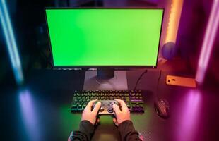 POV of gamer hands playing with joystick on green screen in trendy and stylish room with neon light photo