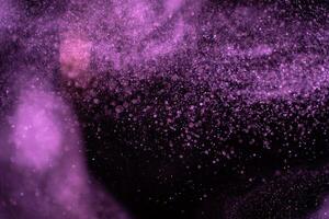 Real blue dust particles on black background. Glittering sparkling bokeh overlay with copy space. photo