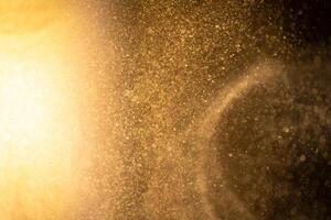 Gold dust particles abstract Bokeh star particle on Black Background. Futuristic dots in space. photo