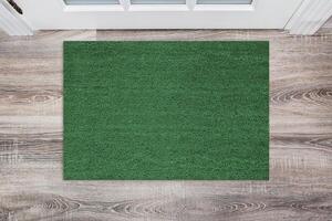 Green Coir Doormat on a wooden floor in front of the door. Product mockup photo