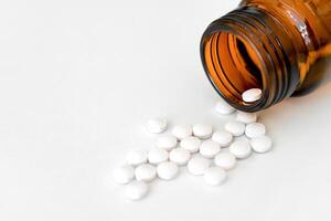 Medication Close-Up, White Pills and Brown Glass Vial Arranged on Table, Copy Space, Close-Up, Healthcare Concept. photo