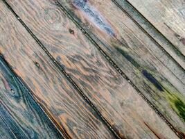 Surface of wooden boards with multicolored spots from dampness, diagonal lines, top view. photo