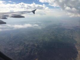 View from Airplane Window of Mountains and Clouds photo