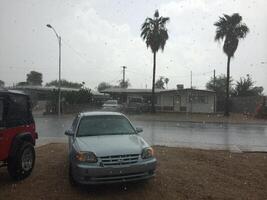 Car Parked in Front Yard During Afternoon Rain Storm in Arizona photo