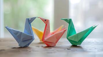 Multicolored of several origami bird from folded paper on the desk photo