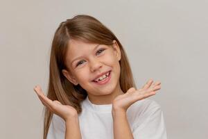 Portrait of caucasian little girl with open wide smile showing good teeth using hands looking at camera on white background photo