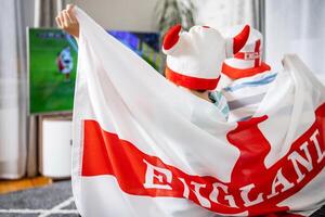 Father and son with England flag watching soccer game on TV photo